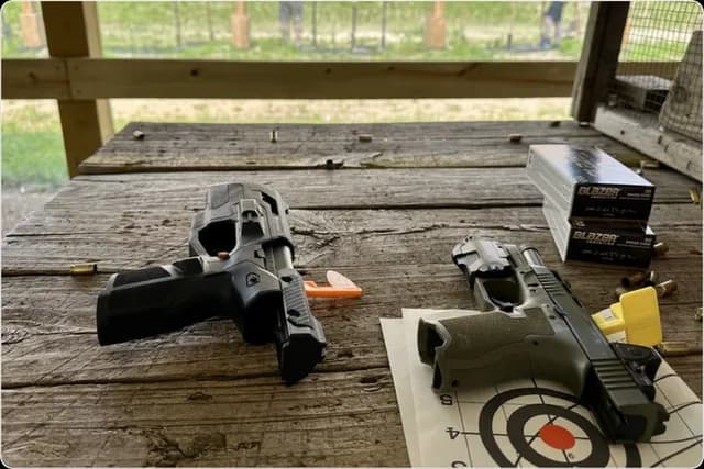 Two Biofire Smart Guns on a wooden table at an outdoor range.