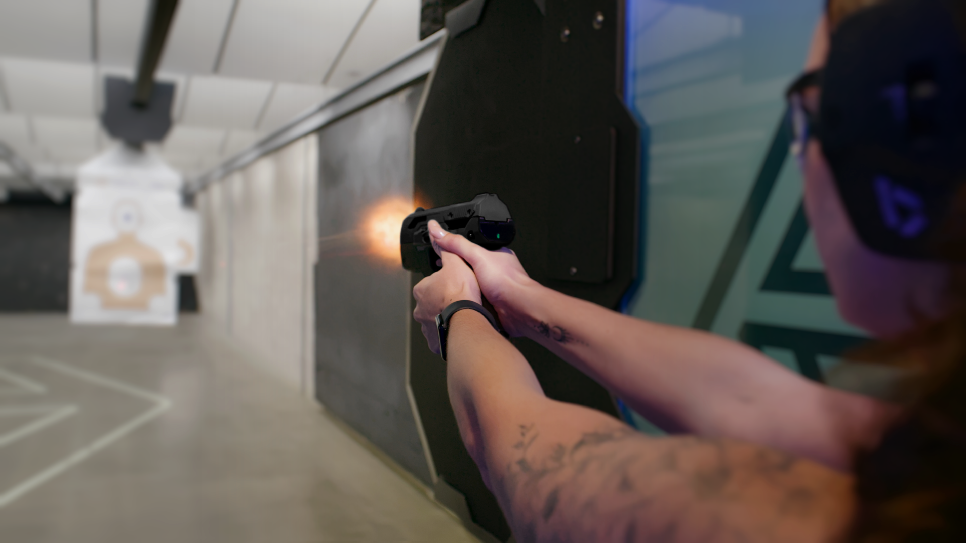 A shooter firing the Smart Gun at an indoor range, with a muzzle flash visible.